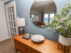 A room with a wooden dresser, a mirror, a lamp, a bowl, and a potted plant. - Rosemount, Marazion, Cornwall (Marazion)