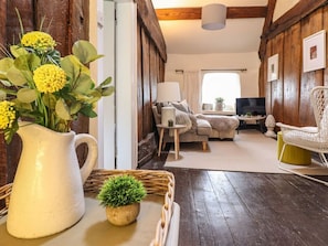 Un salon chaleureux avec une cheminée, un téléviseur et un coin salon confortable.