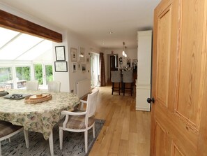 Un comedor con una mesa, sillas y una puerta de madera.