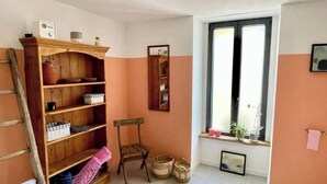 Une pièce avec une bibliothèque en bois, une chaise, une fenêtre donnant sur un beau paysage et un miroir accroché au mur.