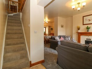 Eine Treppe führt zu einem Essbereich mit einer Couch und einem Kamin.