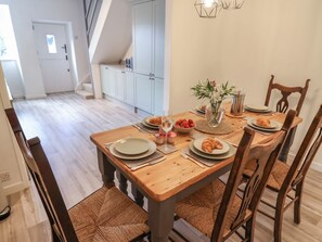Un coin repas avec une table en bois, des chaises et un vase de fleurs.