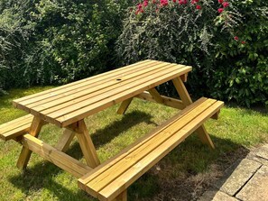 A wooden picnic table with benches in a garden area. - Broadhay, Hathersage (Hope Valley)