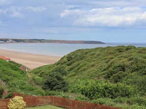 A coastal landscape with a beach, hills, and a wooden fence. - 29 Gap Road, Hunmanby (Filey)