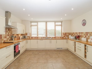 A kitchen with white cabinets, a microwave, a stove, and a window with blinds. - The Old Barn, Swanage (Swanage)