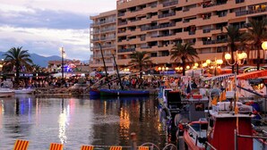A waterfront area with boats, a crowd, and a multi-story building with balconies. - Air-conditioned house for 6 with supervised swimming pool - Beach & port on foot - Terrace (Saint-Cyprien)