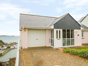 A coastal house with a garage, a covered porch, and a view of the sea. - Charming Pink House with Views (St. Austell)