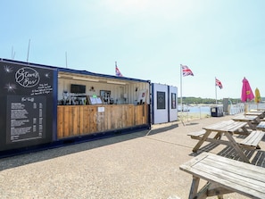 A seaside bar with a wooden counter, flags, and picnic tables. - 5 The Nab House, Bembridge (Bembridge)