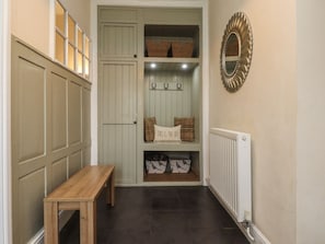 A hallway with a bench, a coat closet with baskets, and a radiator. - Glebe Cottage, Skipton (Skipton)