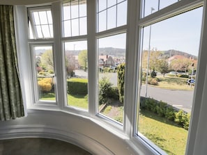 A room with a large window offering a view of a residential street and greenery. - Seawinds 2a, Rhos-On-Sea (Colwyn Bay)