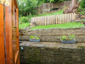 A stone wall with a wooden fence and potted plants. - Holme Cottage, Hebden Bridge (Hebden Bridge)