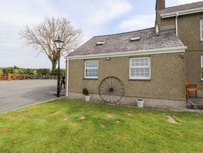 A two-story house with a large wheel, a lamp post, and a paved driveway. - Garreg Wen Isaf Bach, Penygroes (Penygroes)