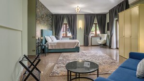 A modern bedroom with a bed, a seating area, and a wardrobe. - Ad Ricezioni Villa Francesca (San Demetrio Corone)
