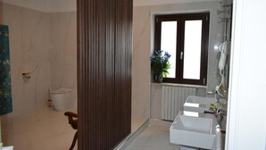 A bathroom with a toilet, a sink, a window, and a radiator. - Ad Ricezioni Villa Francesca (San Demetrio Corone)