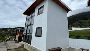 A modern building with large windows, a flat roof, and a small porch area. - Krincing Hills Cabin (Kebonlegi)