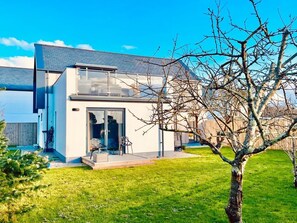 A modern two-story house with a glass door entrance, a small porch, and a well-maintained lawn. - Avalennek, St Newlyn East (Newquay)