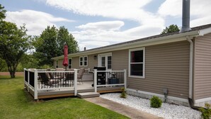 A single-story house with a covered patio area, a chimney, and a small garden.