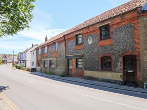 A row of traditional brick buildings with a street in front. - Happy Daze in West Runton. TV. (Cromer)