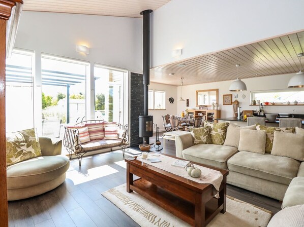 A spacious living room with a sofa, a coffee table, and a fireplace. - Links View Retreat in Fritton (Great Yarmouth)