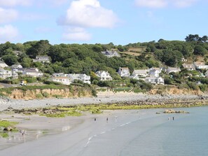 A coastal town with houses on a hillside, a beach, and calm water. - Wide Horizons, Coverack (Helston)