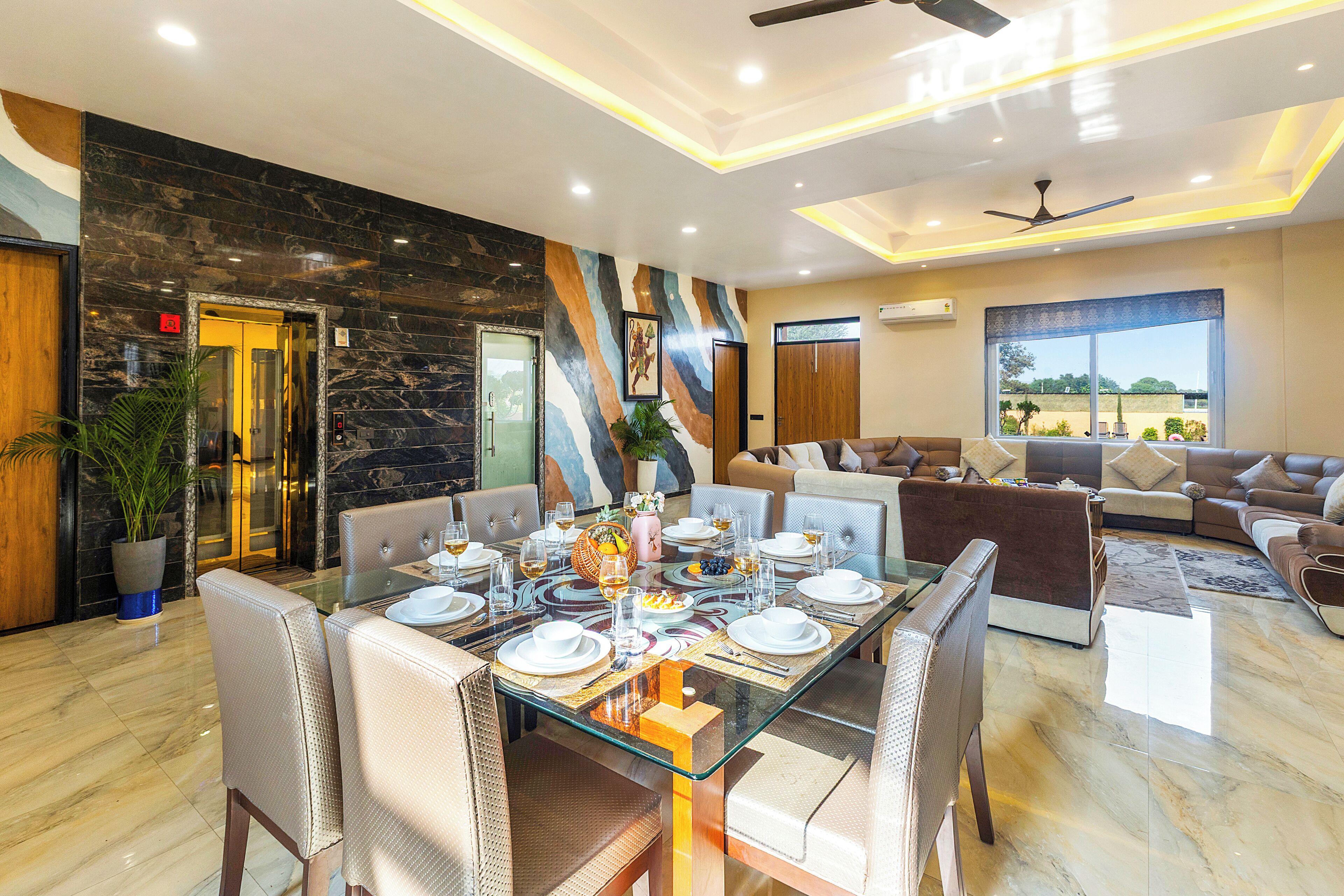 Un moderno vestíbulo de hotel con zona de comedor, asientos y vistas al exterior.