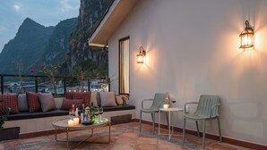 A terrace with a table, two chairs, and a view of mountains. - Yangshuo Lisa Boutique Hotel (Guilin)