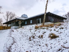 A modern wooden building with a sloped roof, a satellite dish, and a pathway leading to the entrance. - Katchana: A Tranquil Retreat in Kincraig (Kingussie)