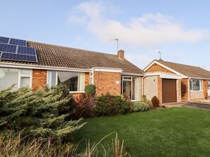 A two-story house with a brick exterior, a tiled roof, and a small front yard with a lawn and shrubs. - Acre View, Sutton-On-Sea (Mablethorpe)