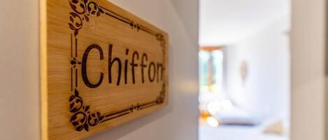 A wooden sign with the word 'Chiffon' on a wall.