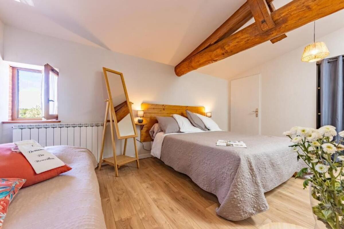 A bedroom with a bed, bedside table, lamp, and a window.