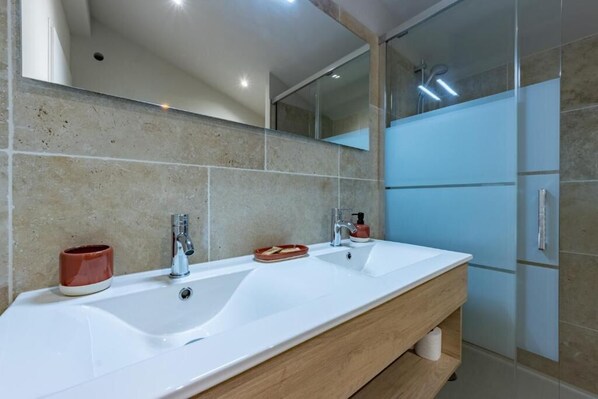A modern bathroom with two sinks, a mirror, and a shower area. - Ô DOMAINE (Saint-Nauphary)