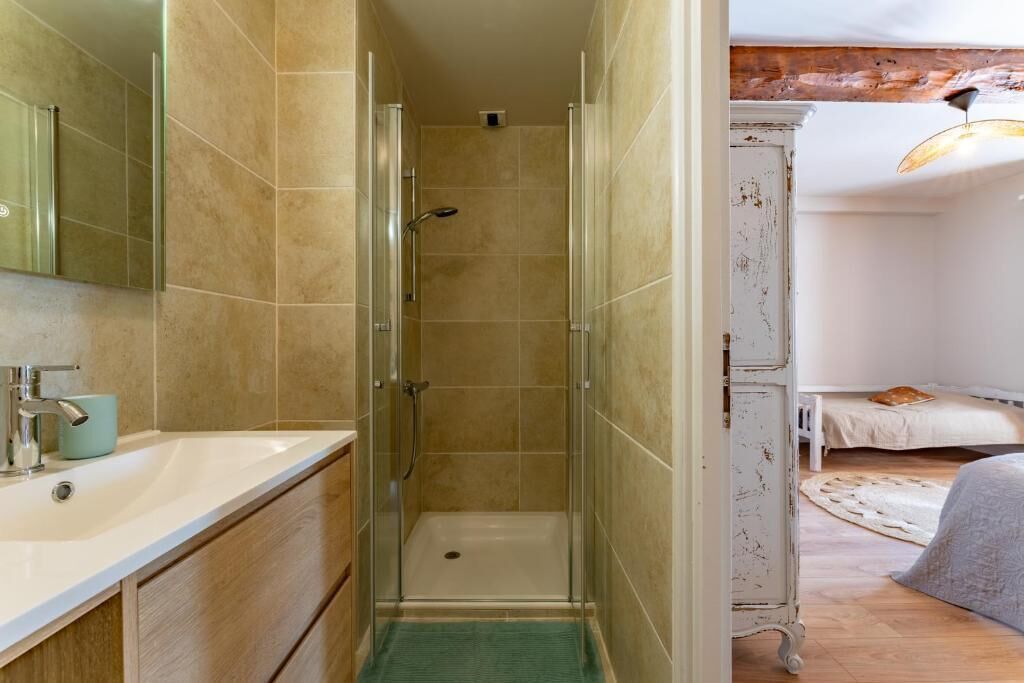 A bathroom with a shower, sink, and mirror.