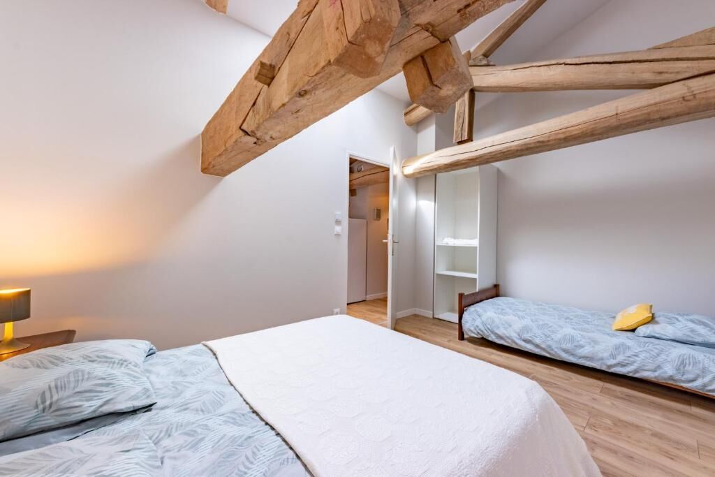 A bedroom with a bed, a bedside table, a lamp, and a wardrobe.