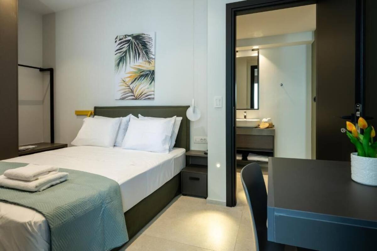 Une chambre d’hôtel moderne équipée d’un lit, d’une table de chevet et d’un bureau avec une chaise.