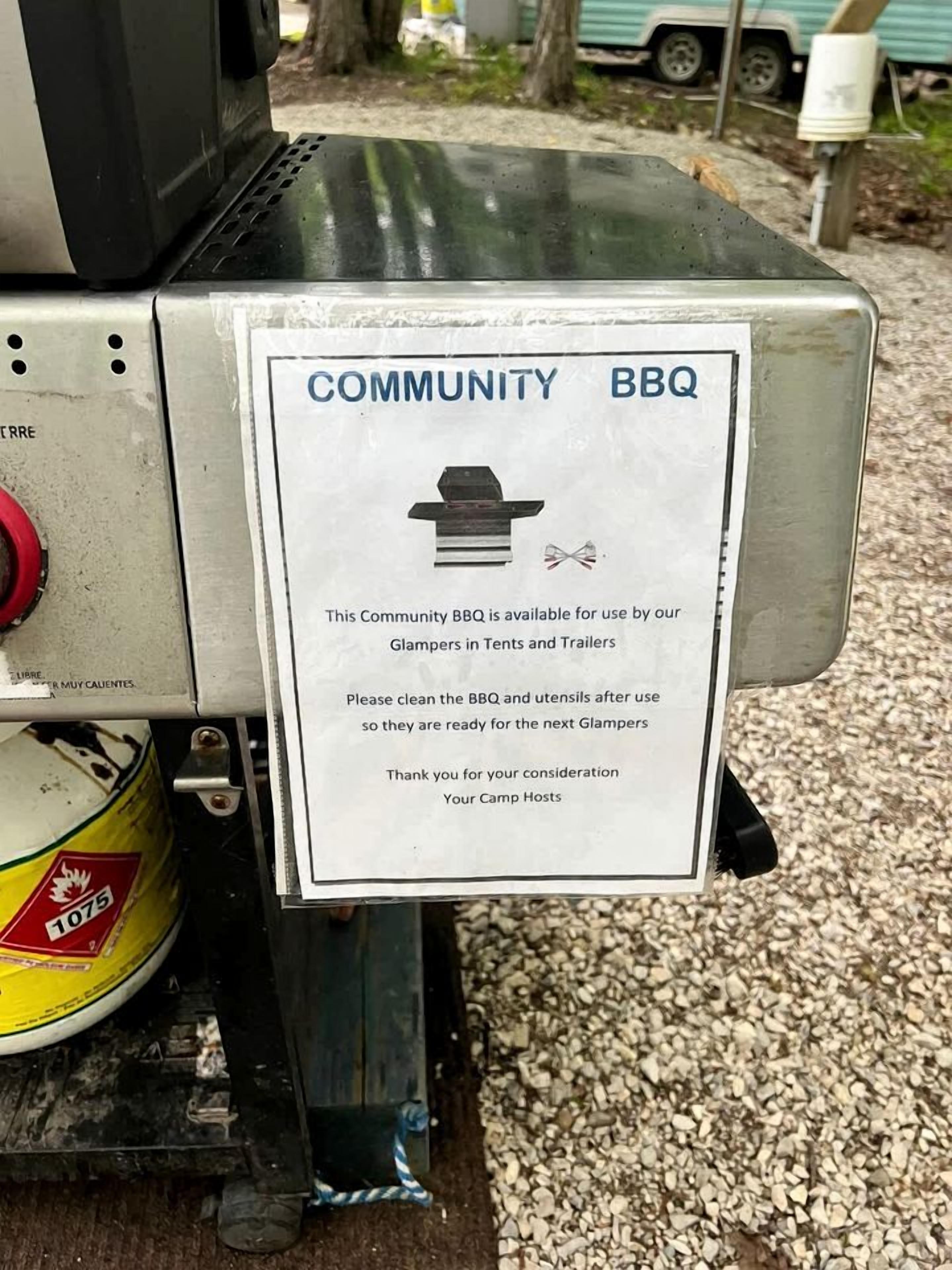 Un barbecue portable destiné à être utilisé en communauté, avec une pancarte indiquant qu’il est réservé aux personnes pratiquant le « glamping » et séjournant dans des tentes ou des caravanes.