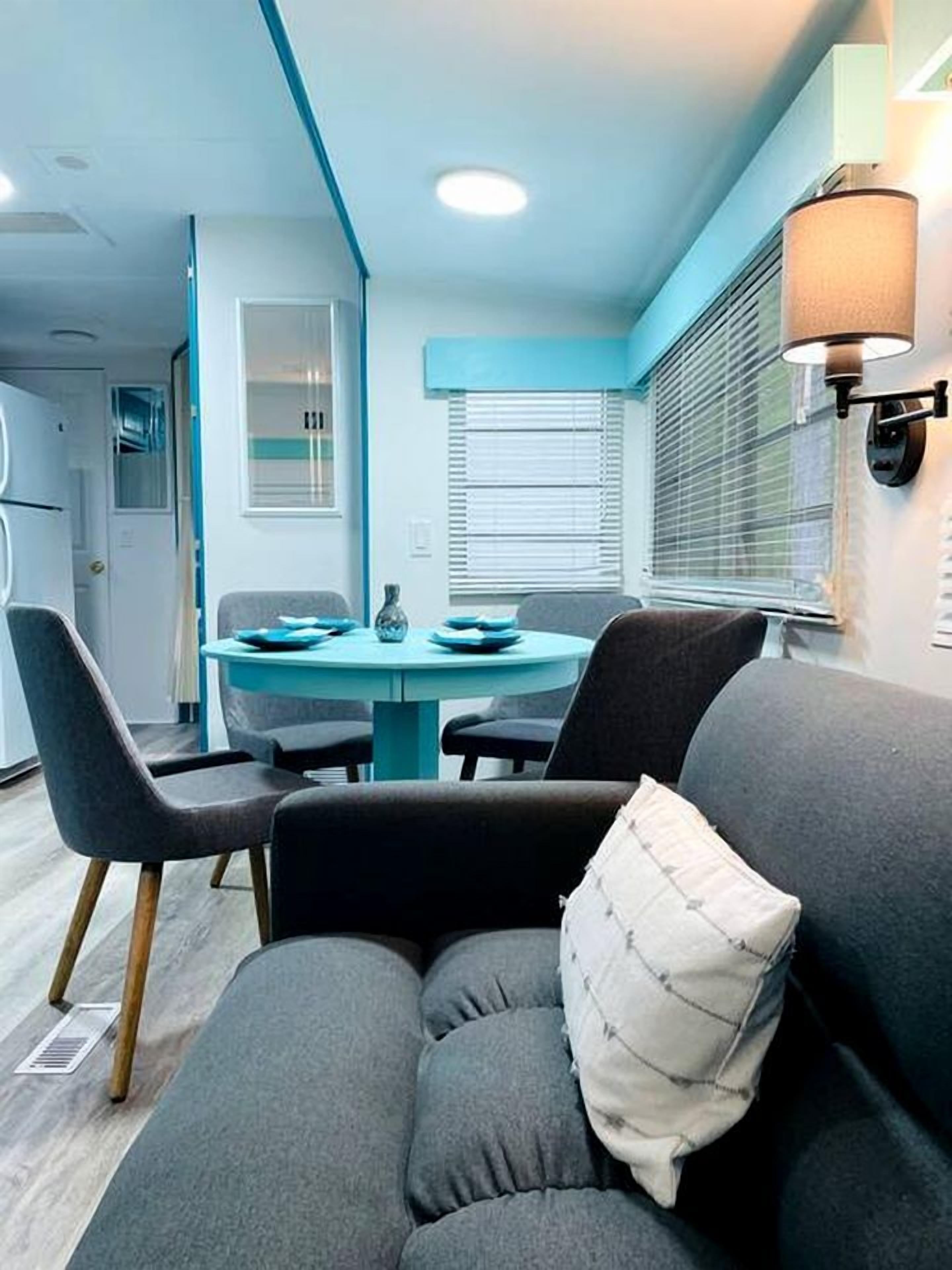 Un espace de vie compact comprenant un canapé, une table à manger et une lampe.