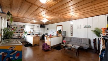 Un intérieur chaleureux avec des plafonds en bois, une kitchenette, un canapé et un petit coin repas.