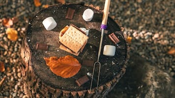 Une bûche avec des guimauves, du chocolat et un bâton.