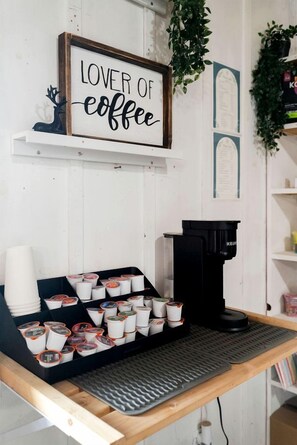 A coffee station with a sign that reads 'LOVER OF coffee,' a coffee machine, and a tray with coffee cups. - Fully Equipped Glamping Caravan near Miller Lake, Perfect for a Weekend Getaway from Toronto (Miller Lake)