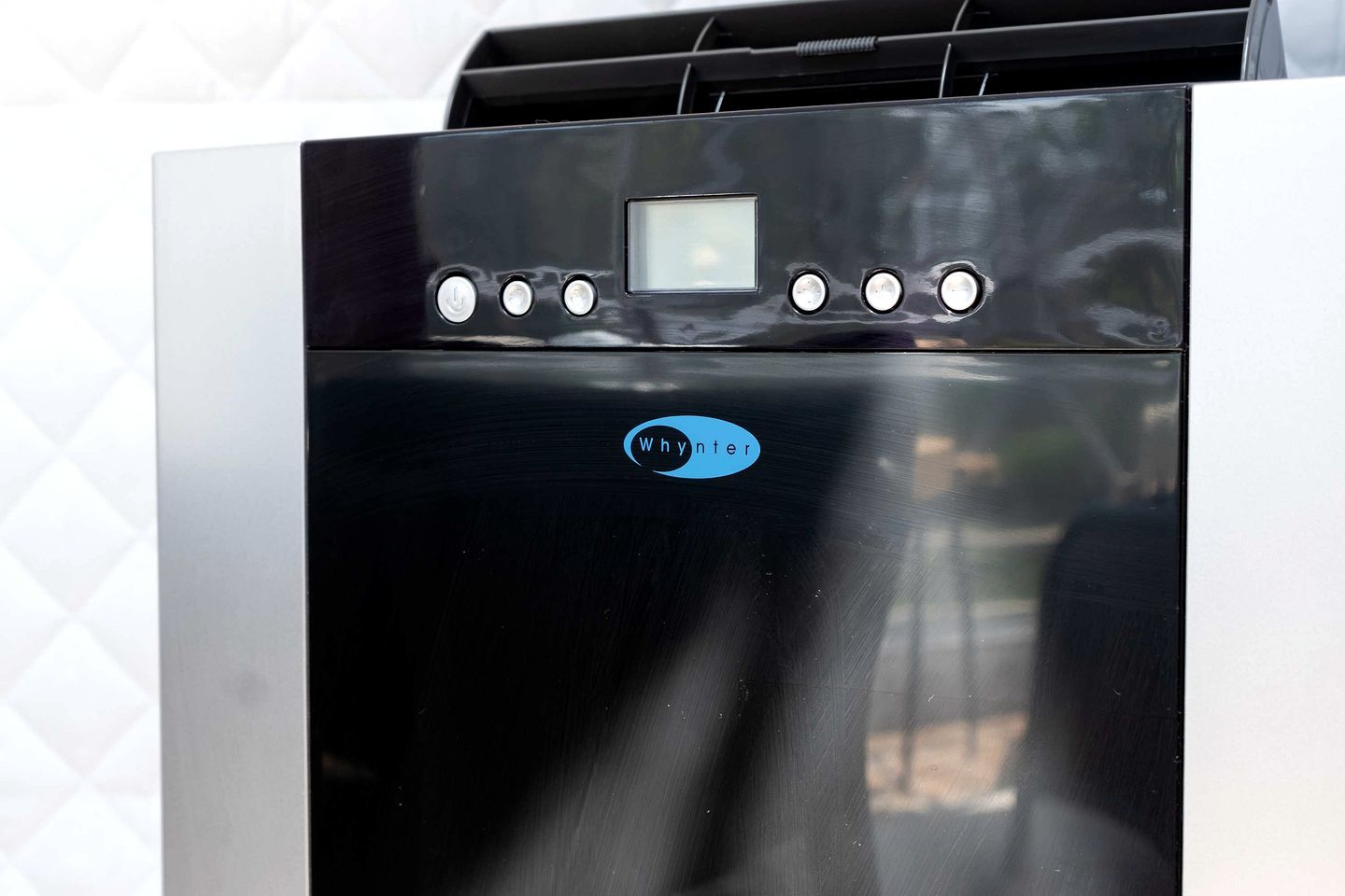 A black, stainless steel appliance with a digital display and multiple control buttons.