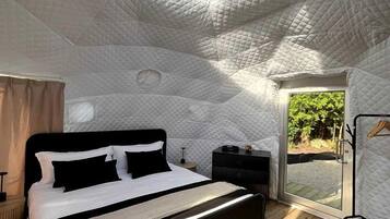 Ein Schlafzimmer mit einem Bett, einem Nachttisch, einem Kleiderschrank und einem Dachfenster.