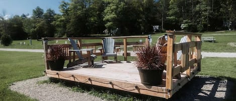 Een houten terras met zitplaatsen en bloempotten.
