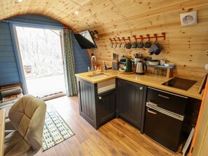 A compact kitchen with wooden cabinets, a sink, a stove, and a refrigerator. - Hobhole, in Keal Cotes, 1-bed. (Spilsby)