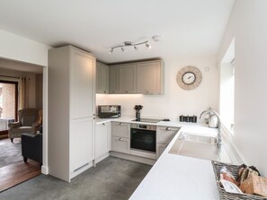 A modern kitchen with white cabinets, a built-in oven, a microwave, and a sink. - Buffers: Cozy Retreat in Whitby (Whitby)