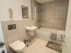 A bathroom with a toilet, sink, and bathtub. - Sailors & Mermaids, Scarborough (Scarborough)