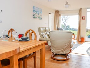 A dining area with a wooden table, chairs, and a view of the outdoors. - Harbour View, Mudeford, Christchurch (Christchurch)