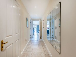 A hallway with a white door, a glass partition, and a tiled floor. - Willow, Maiden Newton (Dorchester)