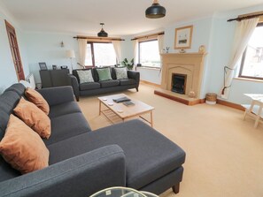 Ein Wohnzimmer mit Sofa, Kamin, Couchtisch und Lampe.