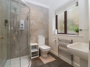 A bathroom with a glass shower enclosure, a toilet, a sink, and a window with a view. - Tudor House, Symonds Yat (Ross-on-Wye)