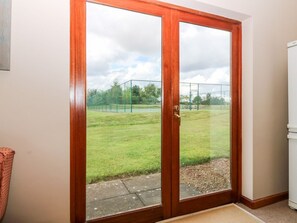 Una puerta corrediza de vidrio que da a una cancha de tenis.